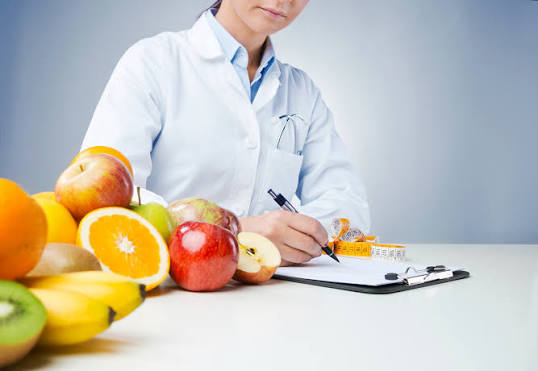 Nutrition specialist with fresh fruit and notes